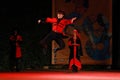 Georgian dancer performing traditional jump on stage